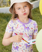 Lavender Unicorn Short Two-Piece Pajama Set - child wearing the short pajamas while painting outdoors