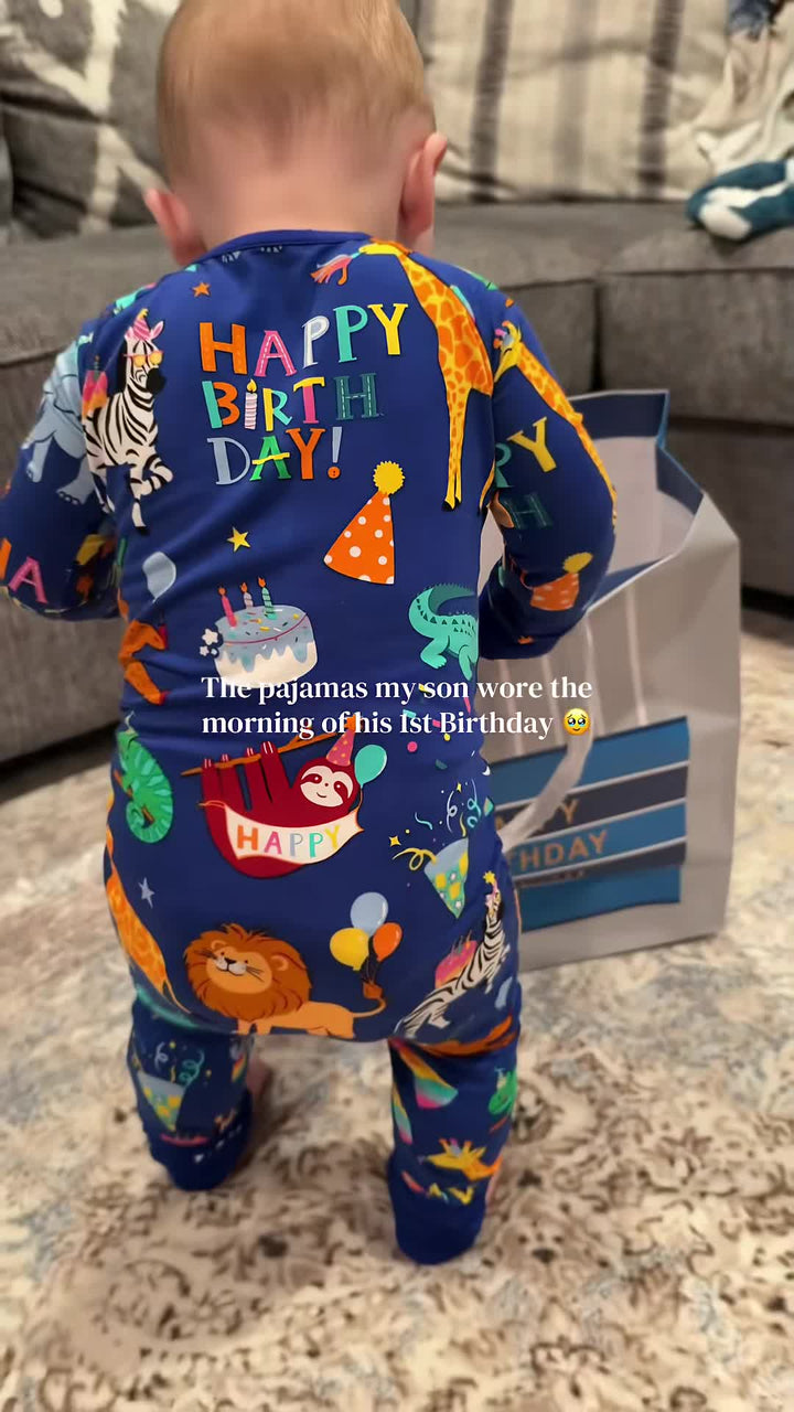 A child wearing blue animal birthday-print pajamas at home.