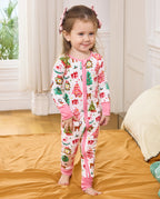 Child standing on orange bedding in the white Blush Christmas zip-up romper.