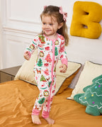 Child standing on bedding with a hand raised in the Blush Christmas romper.