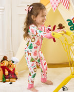 Child standing beside a yellow cart in the Blush Christmas zip-up romper.