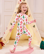 Child standing on a slide with a hand raised in Blush Christmas pajamas.