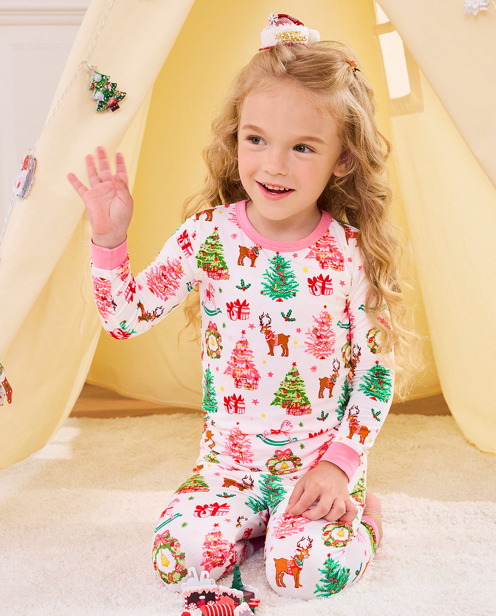 Child waving while seated on a slide in the Blush Christmas set.