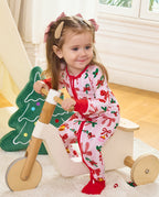 Child seated on a wooden tricycle in the Christmas Bow romper.