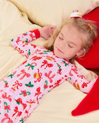 Child lying on bedding in the Christmas Bow long-sleeve top.