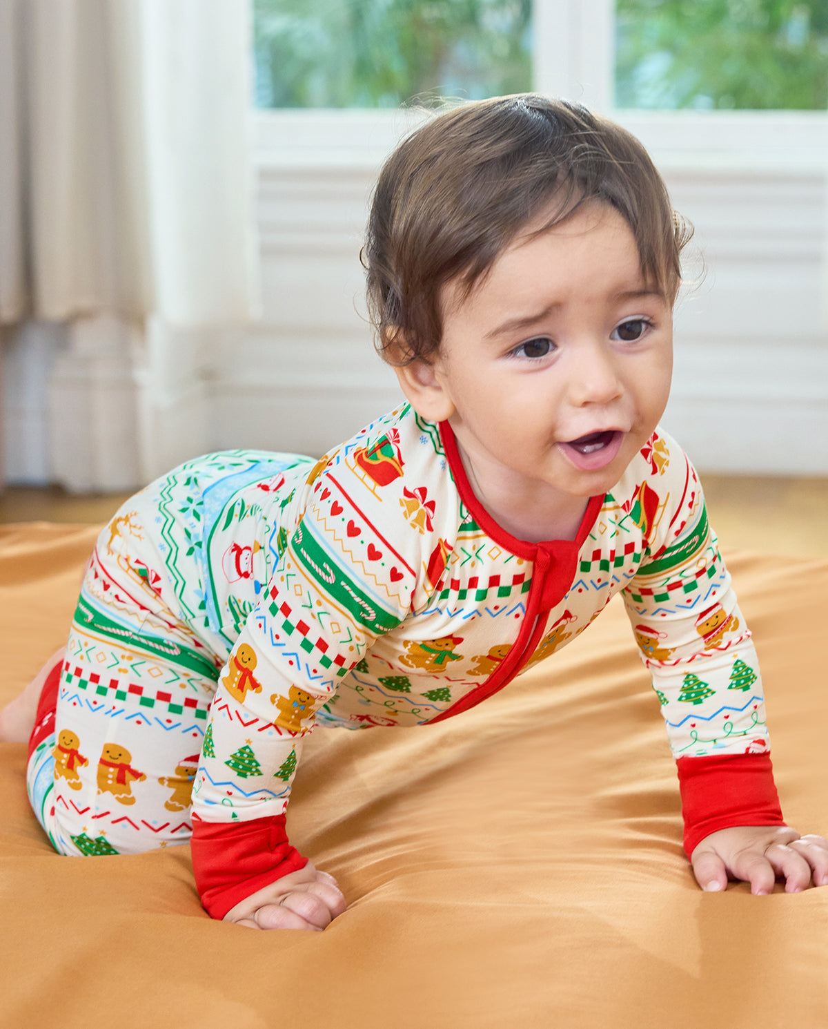 Front view of a smiling baby crawling in the Christmas Fair Isle Bamboo Zippy