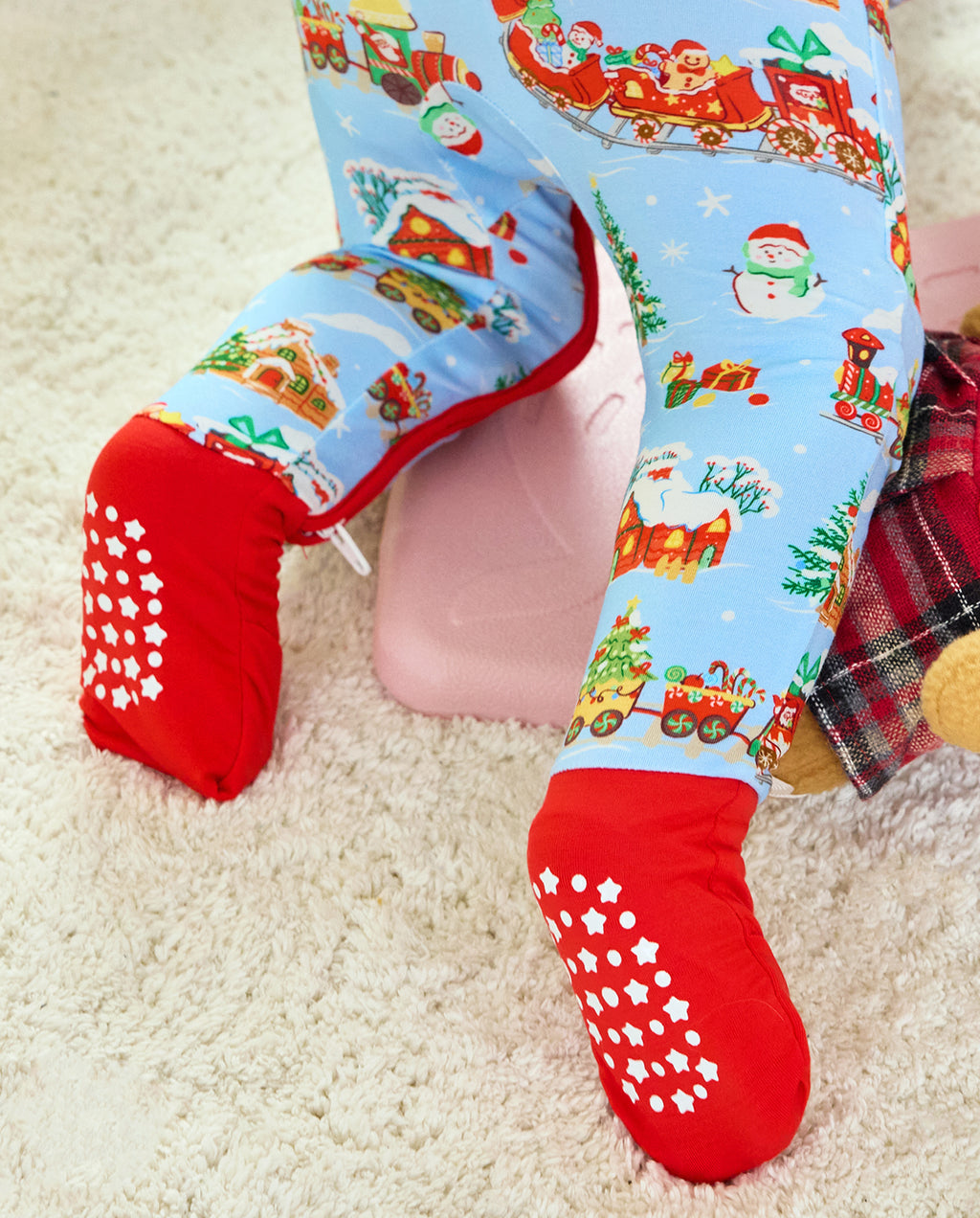 Close-up of the Christmas Trains Bamboo Zippy legs and red covered soles with white grip dots and stars.