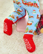 Close-up of the Christmas Trains Bamboo Zippy legs and red covered soles with white grip dots and stars.