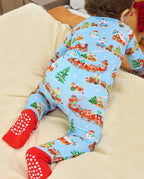 Rear view of a child reclining on a pale sofa in the Christmas Trains Bamboo Zippy, showing the light blue print and red covered feet.