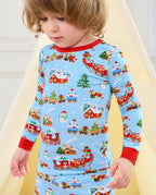 Child looking down at the Christmas Trains pajama top with red cuffs.