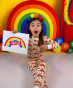 Child showing her rainbow artwork beside matching Createe Cozee custom bamboo pajamas by babee Reshinee