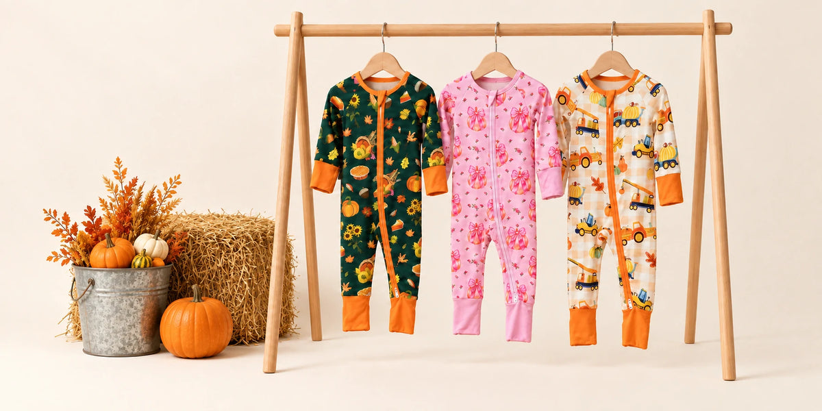 Three colorful baby zippy pajamas hanging on a farmhouse porch in a warm autumn harvest setting.