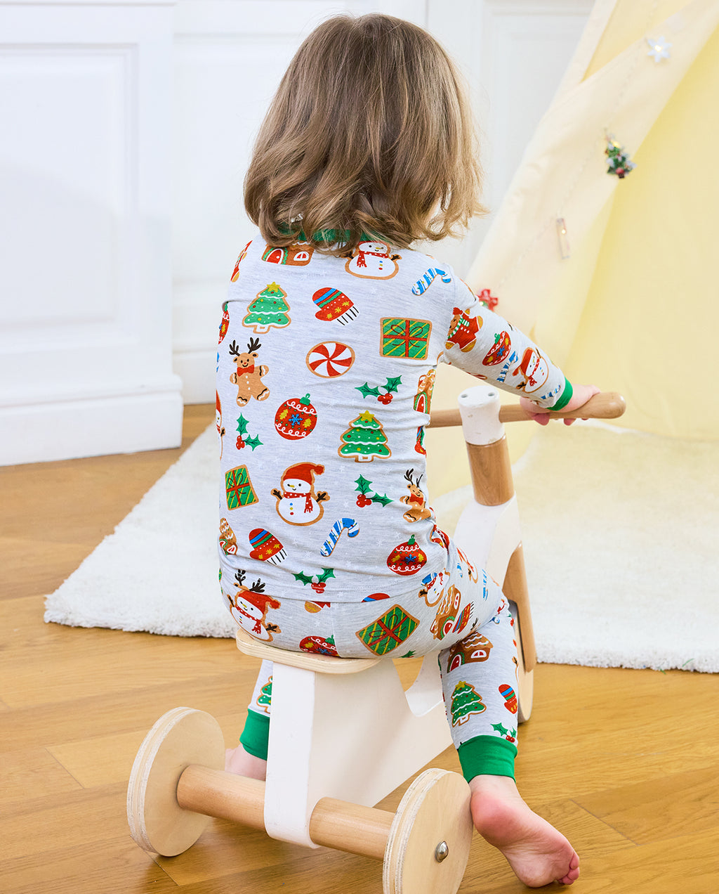 Child kneeling with back to camera in Gingerbread Gala top and pants