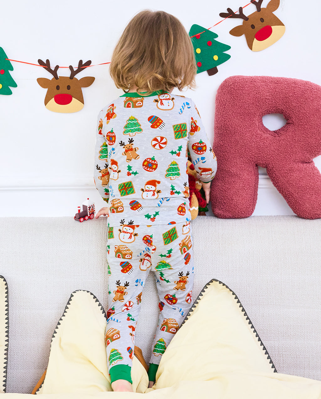 Back close-up of Gingerbread Gala pajamas while a child kneels on a sofa