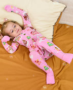 Child reclining on orange bedding with arms raised in the Gingerbread Lane romper.
