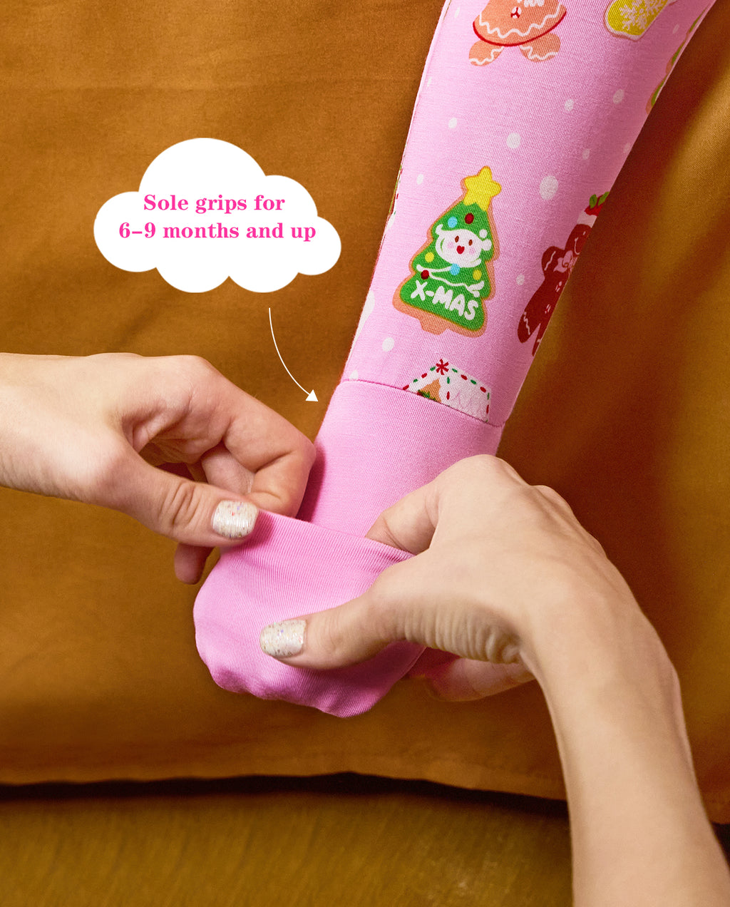 Hands folding a pink foot cuff on the Gingerbread Lane romper, with the original annotation.