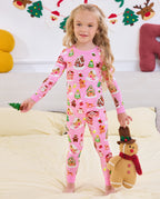 Child standing beside a sofa in the pink Gingerbread Lane two-piece pajamas.