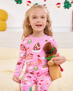 Child holding a gingerbread plush toy in Gingerbread Lane pajamas.