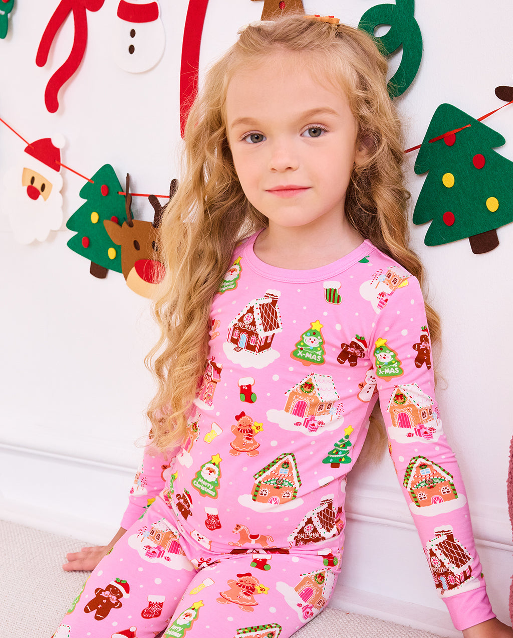 Close view of a child seated in the pink Gingerbread Lane pajama set.