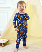 Child standing with arms raised in the navy Hanukkah Magic long-sleeve top and matching pants.