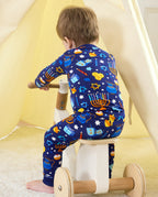 Rear view of a child seated on a wooden tricycle in the Hanukkah Magic two-piece set.