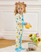 Child holding a yellow watering can while standing in the Happy Hanukkah romper.