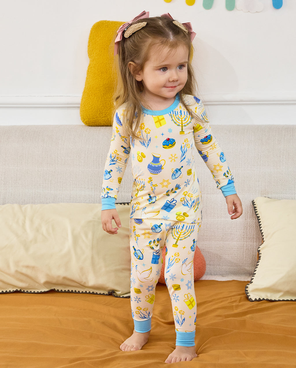 Child standing in the Happy Hanukkah long-sleeve top and matching pants with light blue trim.