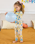 Child holding a pale blue balloon in the Happy Hanukkah pajama set.