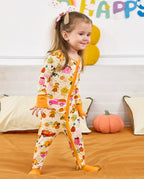 Smiling child standing on a sofa in the Harvest Farm zip-up romper.