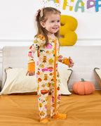 Child standing on a sofa and looking aside in the cream Harvest Farm romper.