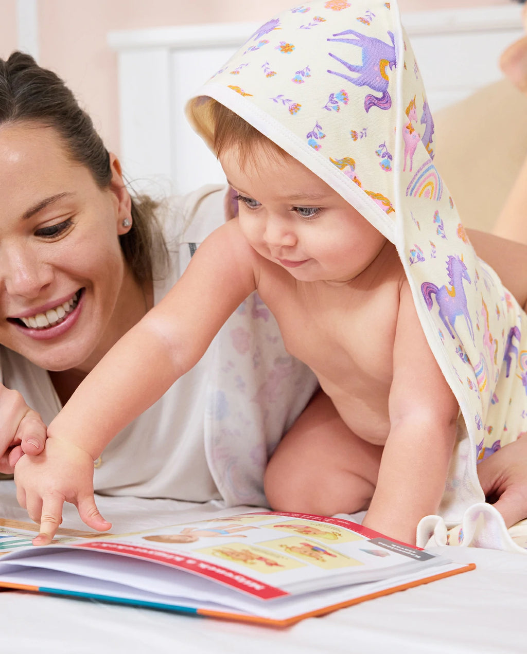 Lavender Unicorn Hooded Baby Bath Towels (2-Pack) - parent and baby reading together under the unicorn-print towel