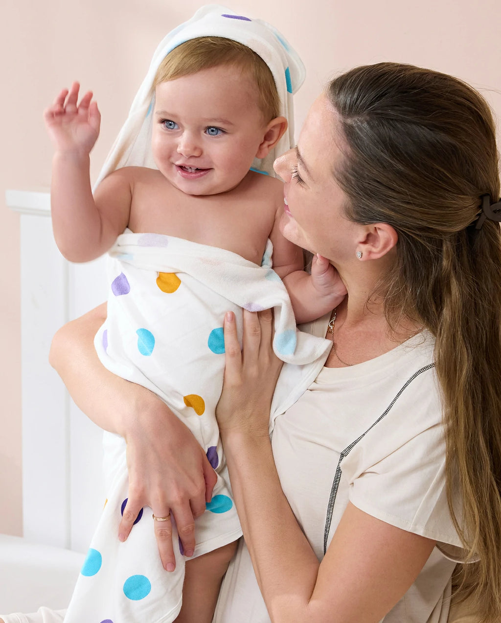 Lavender Unicorn Hooded Baby Bath Towels (2-Pack) - parent cuddling a baby wrapped in the polka-dot towel