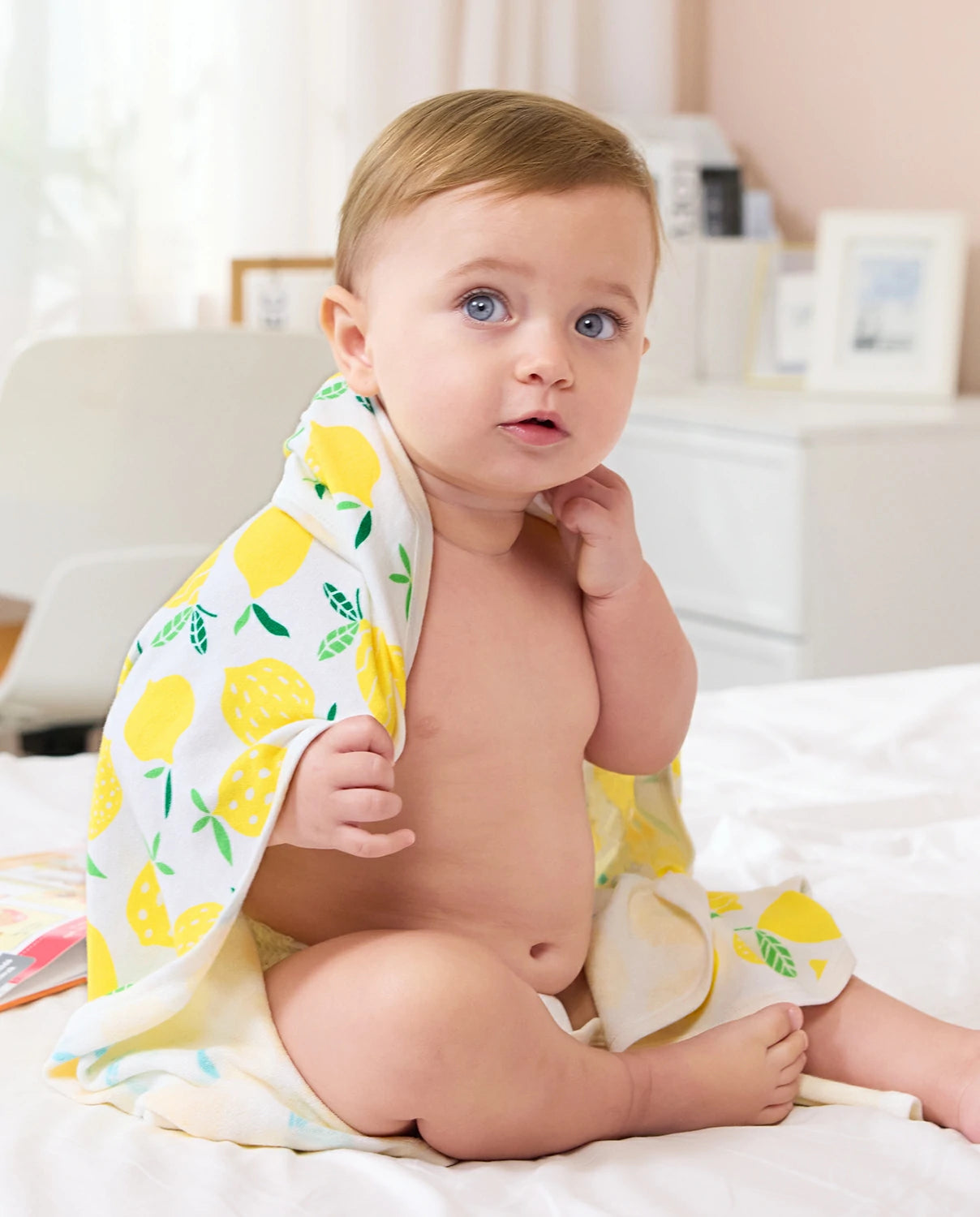 Lemon Tree Hooded Baby Bath Towels (2-Pack) - baby seated while wrapped in the lemon-print hooded towel