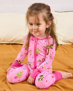 Child seated on bedding looking downward in the Merry Mingo romper.