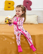 Child seated with a toy camera and bubbles in the Merry Penguins romper.
