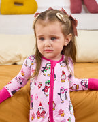 Close view of a child seated in the Merry Penguins romper with deep pink trim.