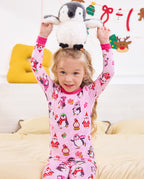 Close front view of a child holding a penguin plush overhead in Merry Penguins pajamas.