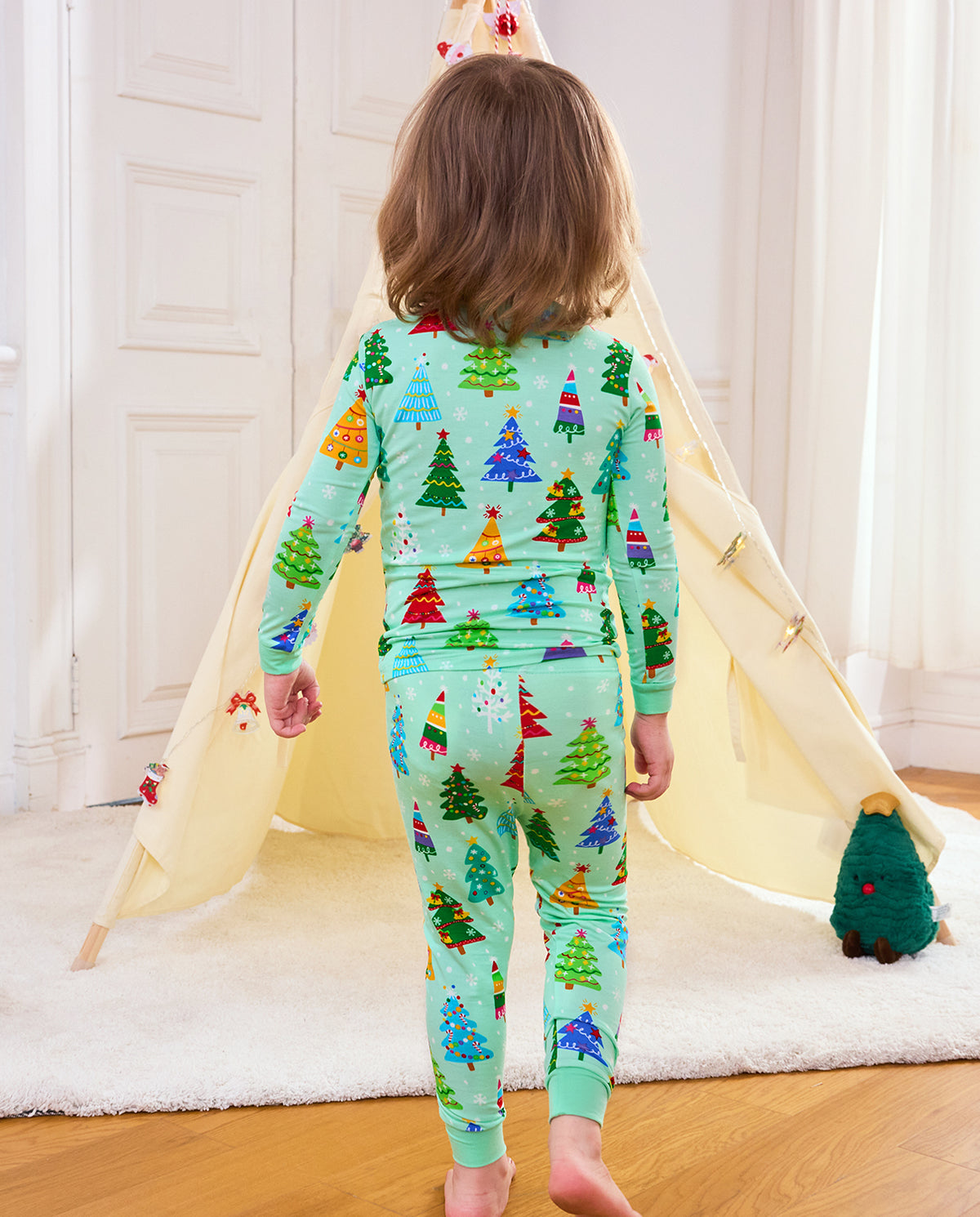 Child standing in Merry Trees pajamas showing the full back of the top and pants
