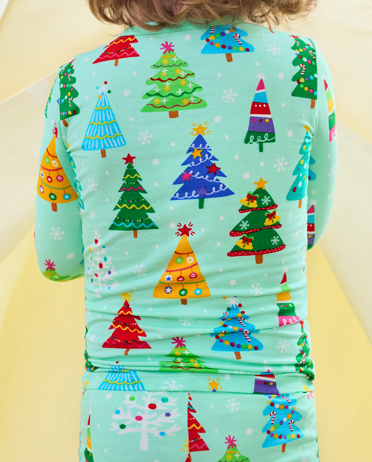 Close-up of colorful Christmas trees and mint trim on the back of Merry Trees pajamas