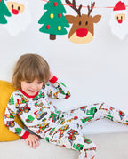 Child reclining on a sofa in Merry Truckmas pajamas beneath holiday decorations