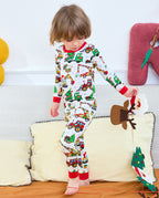 Full front view of a child standing on a sofa in Merry Truckmas pajamas