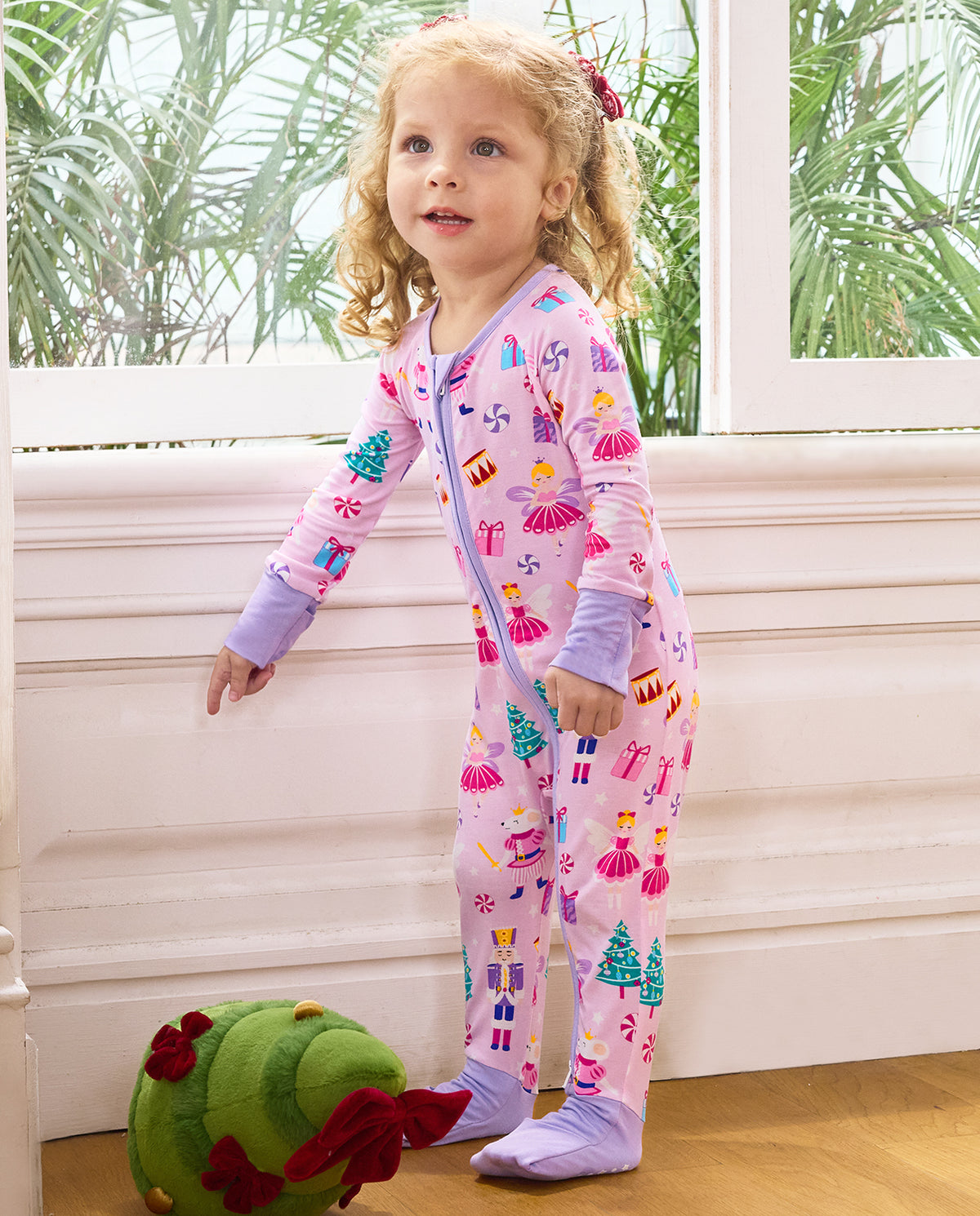 Child standing beside a window in the Nutcracker Fairy romper with lavender cuffs.