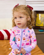Close view of a child seated and holding a small object in the Nutcracker Fairy romper.
