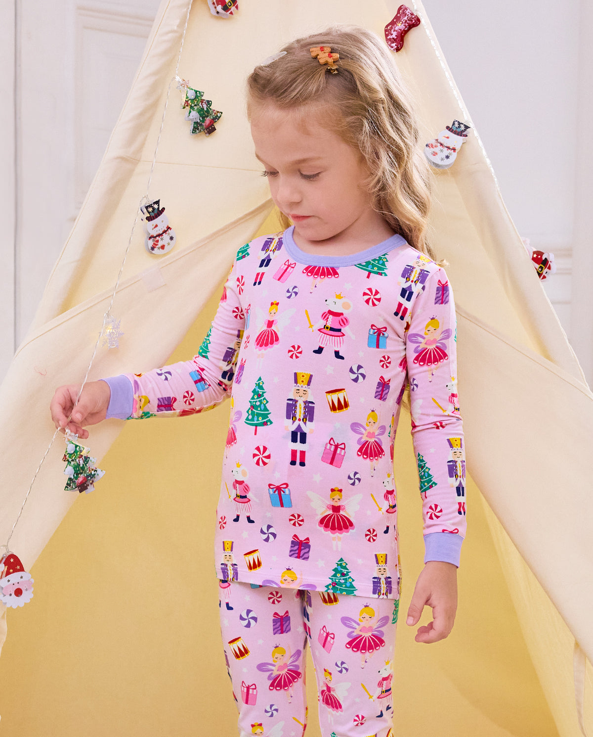 Child looking downward while standing on a slide in Nutcracker Fairy pajamas.