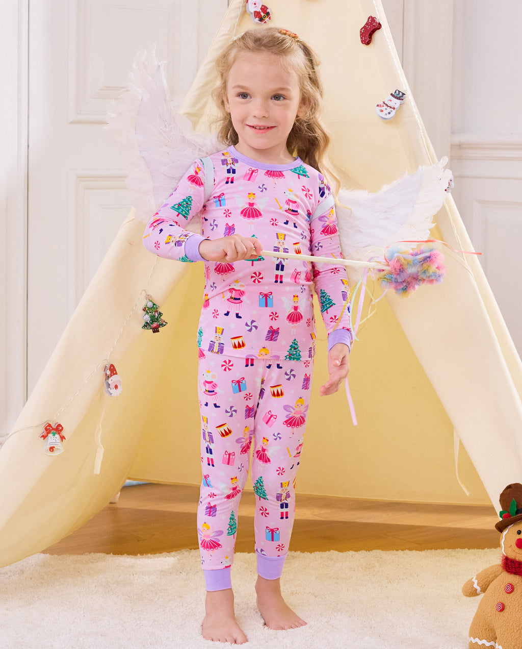 Child seated on a slide holding a wand in Nutcracker Fairy pajamas.