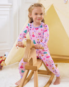 Child seated on a wooden rocking horse in Nutcracker Fairy pajamas.