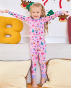 Child seated on a sofa with arms out in Nutcracker Fairy pajamas.