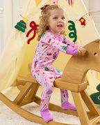 Child seated on a wooden rocking horse in the Pink Nutcracker romper.