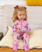 Child seated on a sofa in the Pink Nutcracker romper.