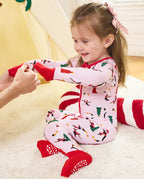 An adult folding a red sleeve cuff over a child's hand on the Pink Penguins romper.